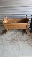 Side view of wooden rocking cradle showing rocker feet and spindle posts