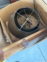 Nested brass metal lamp shades in cardboard box with spider fitters visible