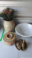 Group shot showing crock with dried flowers, white basin, lidded casserole, plate with small pottery vessels