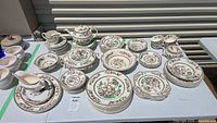 Overview of entire Johnson Bros Indian Tree dinnerware set on table