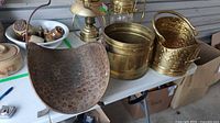 Three brass fireplace buckets on table