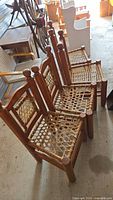 Group of four wooden chairs with damaged woven cane