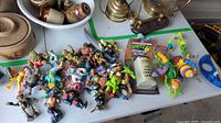 Pile of loose TMNT figures with accessories and carded game on table