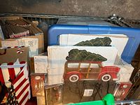Photo showing festive cardboard boxes, cake boards with a Christmas tree vintage car image, and Fischer brand gift bags with gingerbread house designs.
