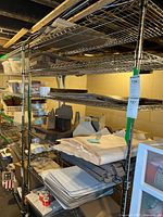 Basement shelving unit holding multiple sealed Staples mailing boxes, fragile labels, and packaging paper inserts.