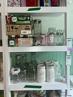 Shelving display showing boxed Ball Mason jars, various loose jars with metal lids, decorative painted jars