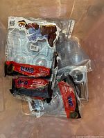 Plastic molds and cocoa bomb molds in two bins, some still sealed in BWB packaging