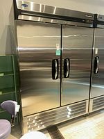 Front view of closed three-door refrigerator showing overall exterior and handles