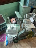 Various metal and wood decorative items including lanterns, clock, birdcages, lobster trap, storage boxes.