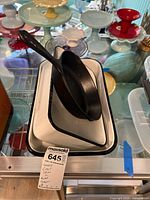 Two enamel pans stacked with a Lodge cast iron skillet placed inside showing overall lot contents.