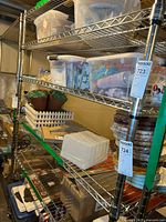 Full view of the four-tier chrome metal wire shelving unit loaded with various household items and storage bins. Unit measures approximately 48 inches wide, 18 inches deep, and 75 inches tall.