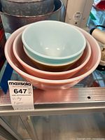 Perspective of four nested vintage Pyrex bowls showing colors and wear.