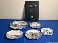 Photo of the five collectible plates arranged on blue cloth backdrop with a black box behind them labeled Lot #63.