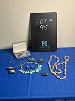 All eight pieces displayed on blue cloth with lot identifier in background