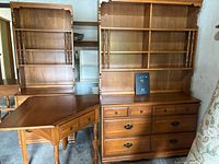Front view of wooden desk set including a corner desk, drawer set, and hutch with shelves and drawers.