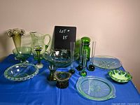 Full view of all glass items on display, showing variety of green and clear glassware including bowls, plates, vases, and decorative pieces.