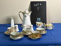 Wide shot showing the entire set including jug, teacups with saucers, creamer, sugar bowl, bud vase, and salt & pepper shakers.