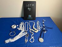 Photo showing set of mostly white costume jewelry including multiple necklaces, bracelets, earrings with black and white accents.