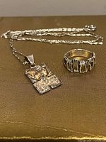 Pendant necklace and ring displayed