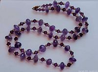 Full view of necklace coiled to show bead arrangement and clasp