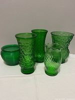 All five emerald green glass vases, front and group view
