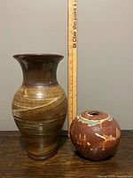 Both stoneware vases beside ruler showing relative size