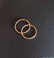 both hoop earrings on black background