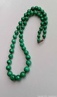 Full view of graduated malachite bead necklace coiled