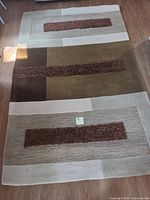 Full view of rectangular geometric area rug showing color blocks and shag pile strips