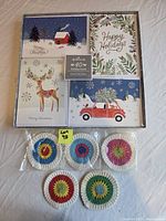Box of 40 Hallmark holiday cards and five crocheted coasters displayed.