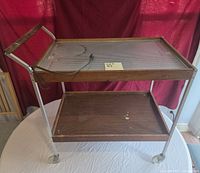 Full view of Salton HotTray trolley showing heated glass top, wood trim, metal frame, lower shelf and power cord