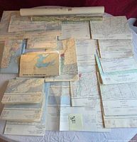 Assorted folded and rolled maps and charts spread on table
