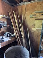 Long narrow wooden moulding strips leaning against wall, various profiles and woods