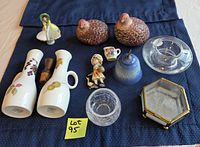 All items laid out including oil and vinegar bottles, duck shakers, porcelain figurines, blue bell, glass cup and saucer, crystal bowl, glass trinket box