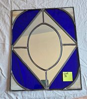 Front view of rectangular stained glass panel with blue glass corners and mirror center