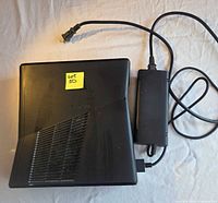 Top view of Xbox 360 console with attached power supply brick and cord