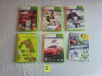 Six Xbox 360 game cases laid out on table