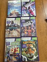 Front view of six Xbox 360 Kinect game cases laid out on table