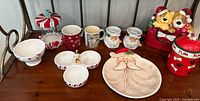 Full view of assorted Christmas-themed mugs, plate, divided dish and glass jar with peppermint lid