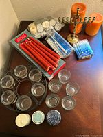Overview of all candles, holders, and menorah on a table including taper candles, votives, pillar candles, and menorah