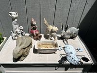 Overall photo showing all garden decor items arranged on table outdoors in sunlight