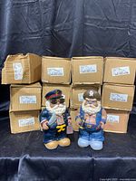 12 pirate banks in original boxes stacked in background with two pirate banks displayed in front.