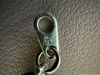 Close-up photo of the silver clasp of the necklace showing '925' sterling silver mark.