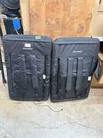 View of two black Alpcour padded folding stadium chairs showing backpack straps on the back for carrying.
