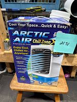 Front and side views of the retail box for Arctic Air Chill Zone personal evaporative air cooler, showing product features and colored LED night light.
