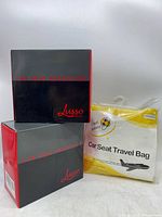 Photo showing two Lusso branded boxed car seat protectors and one yellow and white packaged car seat travel bag together.