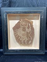 Front view of carved stone art piece in shadow box frame showing full figure etching.