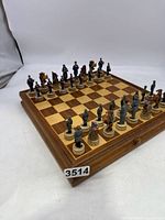 Full view of the chessboard with all pieces set up. Pieces are arranged in two rows on each side with the drawer visible beneath.