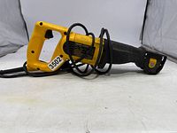 Left side view of the yellow DeWalt DW304P reciprocating saw with black grip and cord wrapped around the handle and body.