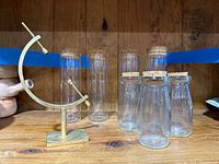 Photo showing entire set of glass jars and gold sphere holder on wooden surface